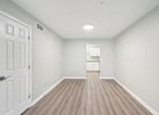 Thumbnail 47 of 55 - A room with a white door and a wooden floor.