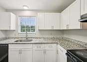 Thumbnail 3 of 55 - A kitchen with white cabinets and granite countertops.
