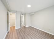 Thumbnail 15 of 55 - A room with a wooden floor and white walls.
