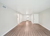 Thumbnail 9 of 55 - A room with wooden flooring and white walls.