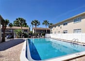 Thumbnail 14 of 17 - A swimming pool in front of a building with a white fence.
