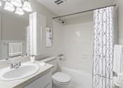 Thumbnail 12 of 18 - A white bathroom with a toilet, sink, and shower.