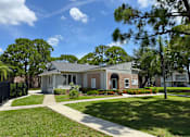 Thumbnail 17 of 21 - A house with a white fence and a green lawn.