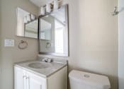 Thumbnail 10 of 13 - A bathroom with a sink, mirror, and toilet.