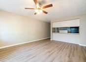 Thumbnail 3 of 13 - A room with a ceiling fan and light fixture.