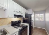 Thumbnail 2 of 17 - a kitchen with white cabinets and a black stove top oven