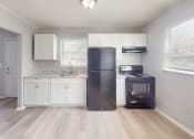 Thumbnail 1 of 17 - a kitchen with white cabinets and a black refrigerator