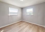 Thumbnail 8 of 17 - a bedroom with two windows and a hardwood floor