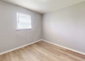 Thumbnail 9 of 17 - a bedroom with hardwood floors and grey walls