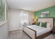 Thumbnail 12 of 35 - A bedroom with a large bed and a green wall.