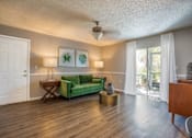 Thumbnail 9 of 35 - A living room with a green couch and a white door.