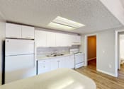 Thumbnail 5 of 9 - A kitchen with white cabinets and a refrigerator.