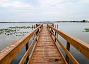 Thumbnail 29 of 35 - A wooden pier extends into a calm body of water.