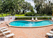 Thumbnail 30 of 35 - A pool surrounded by a brick patio and lounge chairs.