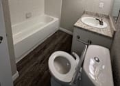 Thumbnail 21 of 39 - A white toilet sits next to a sink in a small bathroom.