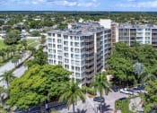 Thumbnail 31 of 33 - an aerial view of a tall building surrounded by trees and a parking lot at Fairways of Inverrary, Lauderhill, Florida