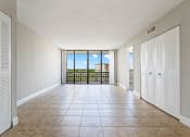 Thumbnail 7 of 33 - an empty living room with a balcony and a tiled floor at Fairways of Inverrary, Lauderhill, 33319