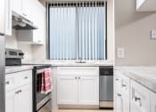 Thumbnail 4 of 33 - a kitchen with white cabinets and a stove and a window at Fairways of Inverrary, Lauderhill, Florida