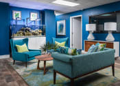 Thumbnail 21 of 33 - a living room with blue chairs and a fish tank at Fairways of Inverrary, Lauderhill, 33319