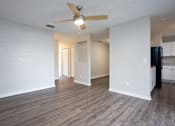 Thumbnail 4 of 31 - A room with a ceiling fan and wooden flooring.