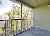 Thumbnail 28 of 31 - A patio with a metal railing and a view of a residential area.