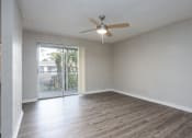 Thumbnail 5 of 31 - A room with a ceiling fan and sliding glass doors.