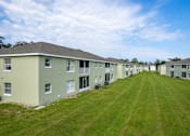 Thumbnail 18 of 31 - A long row of identical houses with green lawns.
