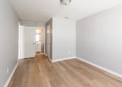 Thumbnail 14 of 31 - A long hallway with wood floors and white walls.