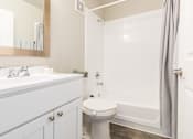 Thumbnail 17 of 31 - A white toilet sits in a bathroom next to a sink and a bathtub.