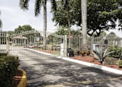 Thumbnail 32 of 33 - A gated entrance with a sign and a mailbox.