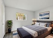 Thumbnail 10 of 15 - A bedroom with a large bed and a potted plant.