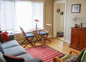 Thumbnail 14 of 16 - a living room with a table and chairs and a couch