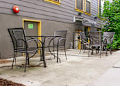 Thumbnail 9 of 16 - a patio with tables and chairs outside of a building