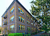 Thumbnail 4 of 16 - a red brick apartment building with yellow and black windows