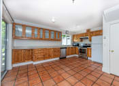 Thumbnail 44 of 64 - a kitchen with wooden cabinets and a tiled floor