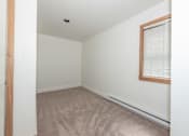 Thumbnail 15 of 64 - a bedroom with white walls and a wooden floor