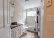 Thumbnail 27 of 64 - a bathroom with a white toilet next to a white bath tub