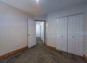 Thumbnail 22 of 64 - a bedroom with two doors and a carpeted floor