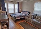 Thumbnail 15 of 16 - a bedroom with a bed and a couch and a table
