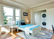 Thumbnail 12 of 16 - a bedroom with a bed and a washing machine