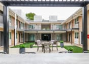 Thumbnail 16 of 18 - a patio with a table and chairs in the middle of a building