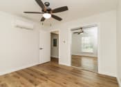 Thumbnail 12 of 18 - a bedroom with hardwood floors and a ceiling fan