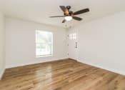 Thumbnail 2 of 18 - a bedroom with hardwood floors and a ceiling fan