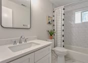 Thumbnail 5 of 18 - A white bathroom with a sink, toilet, and bathtub.