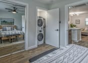 Thumbnail 4 of 18 - A bedroom with a washer and dryer in the doorway.