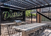Thumbnail 17 of 18 - A sign that says "The District" is displayed in front of a patio area.