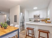 Thumbnail 1 of 18 - A kitchen with a wooden table and white chairs.
