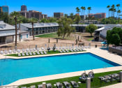 Thumbnail 37 of 95 - an aerial view of the pool at the resort on a sunny day at Presidio Palms Apartments, Tucson, 85701