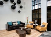 Thumbnail 14 of 95 - a resident lounge with couches chairs and a table at Presidio Palms Apartments, Tucson, AZ