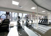 Thumbnail 18 of 95 - a gym with cardio equipment and a large window at Presidio Palms Apartments, Tucson, 85701